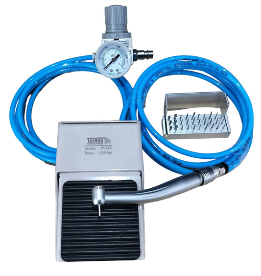 A pneumatic foot pedal kit with a silver metal foot pedal, blue air hose, pressure gauge, and a small accessory tray, displayed on a light wood tabletop.